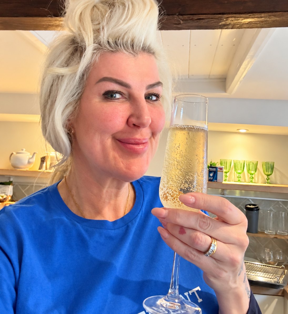 Penny Dee in her kitchen with a glass of fizz